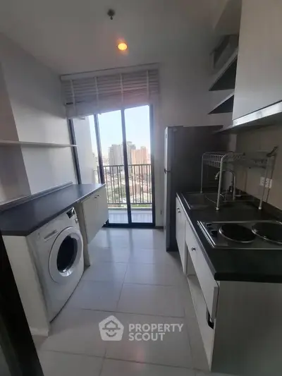 Modern kitchen with city view, featuring sleek appliances and ample natural light.