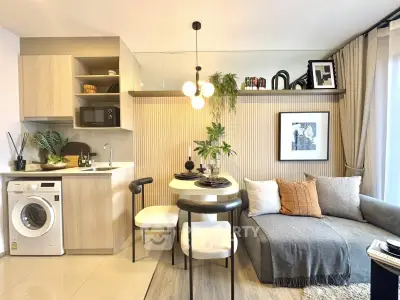 Modern living room with stylish decor, compact kitchen, and cozy seating area in a contemporary apartment.