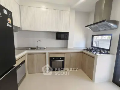 Modern kitchen with sleek cabinetry, built-in oven, and gas stove in a contemporary home.