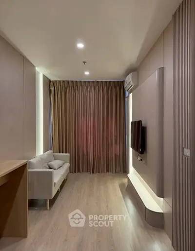 Modern living room with sleek design, featuring a wall-mounted TV and elegant curtains.