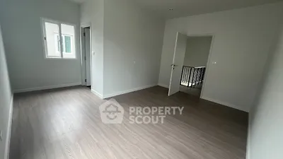 Spacious empty room with wooden flooring and natural light, ideal for customization.