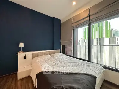 Modern bedroom with large window and city view, featuring a cozy bed and stylish decor.