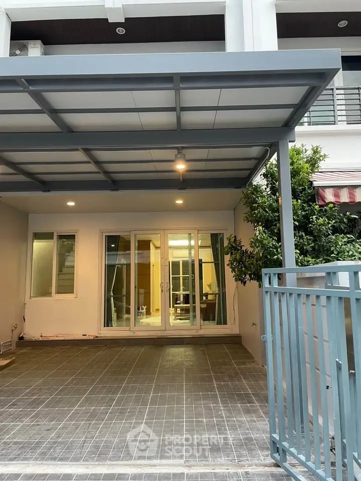 Modern townhouse entrance with covered parking and glass doors