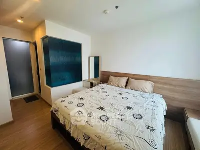 Spacious bedroom with modern decor and wooden flooring in a stylish apartment.