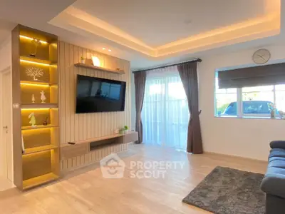 Modern living room with stylish lighting, large TV, and elegant decor, featuring a cozy ambiance and natural light.