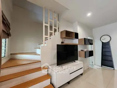 Modern living room with stylish staircase and sleek TV setup