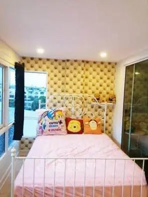 Charming bedroom with cozy decor and large windows offering natural light.