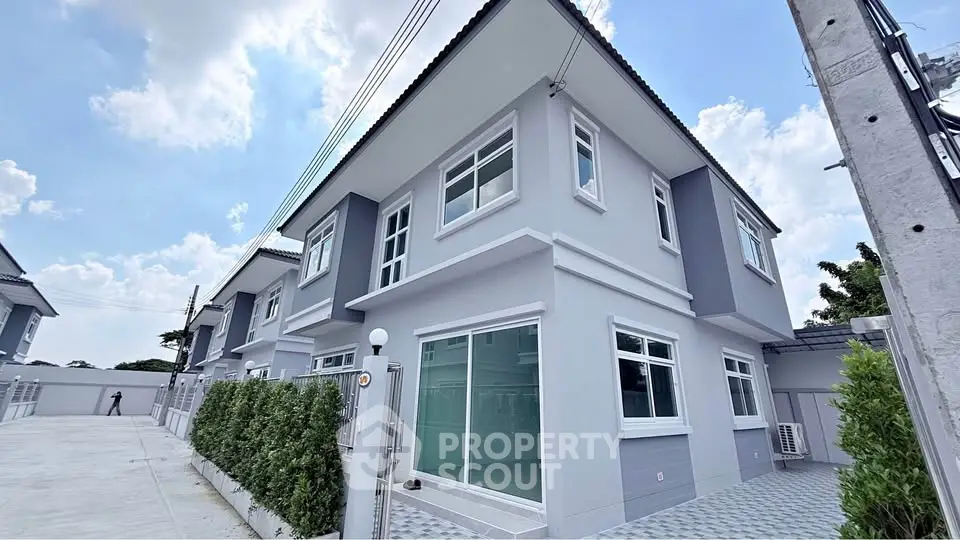 Modern two-story gray house with large windows and a well-maintained exterior.