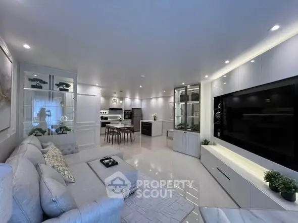 Luxurious modern living room with open kitchen, sleek design, and elegant lighting.