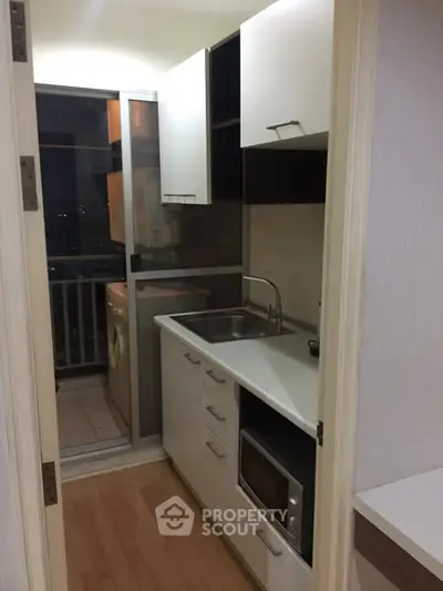 Compact modern kitchen with balcony view and sleek appliances