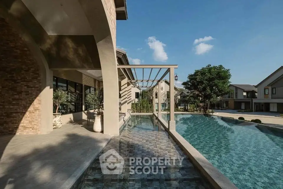 Luxurious villa with stunning pool and modern architecture under clear blue sky.