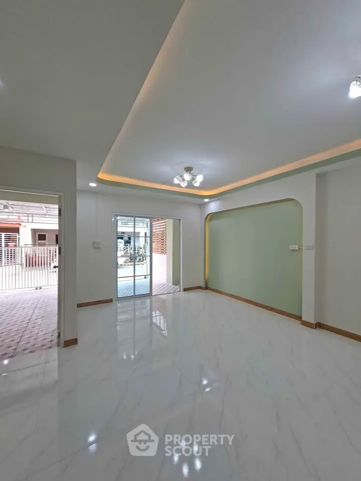Spacious modern living room with elegant lighting and glossy flooring, perfect for family gatherings.