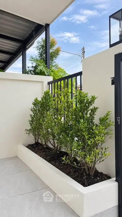 Modern balcony with sleek design and lush greenery, perfect for relaxation and outdoor enjoyment.