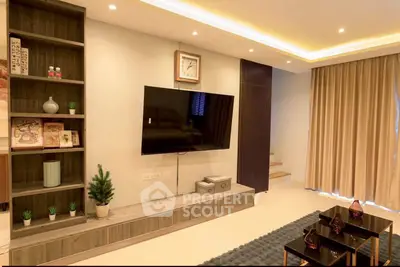 Modern living room with wall-mounted TV, stylish shelving, and elegant lighting.