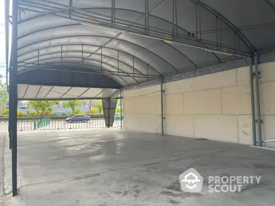 Spacious industrial-style covered parking area with durable metal roof and open sides.