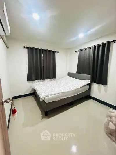 Cozy bedroom with modern bed and dark curtains, perfect for restful nights.