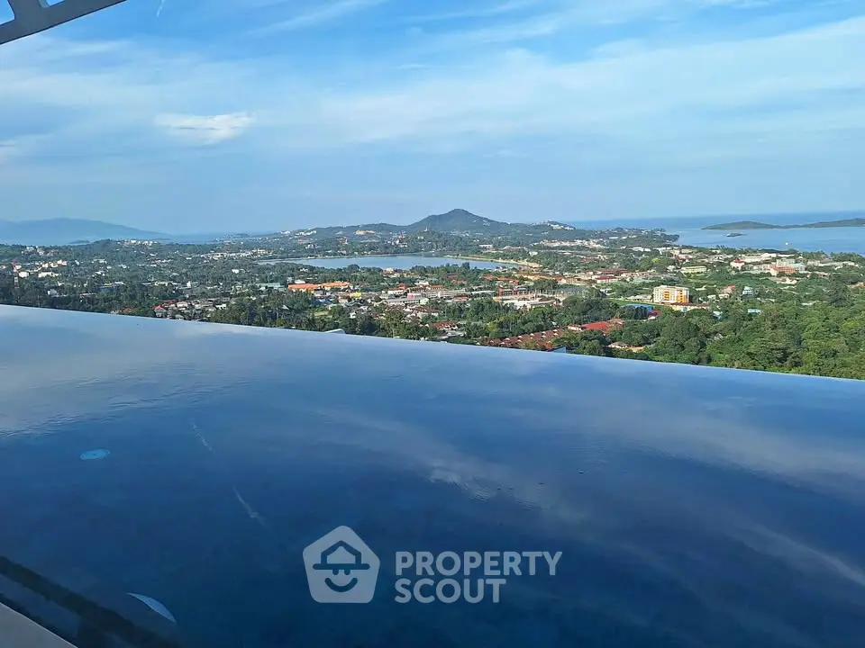 Stunning infinity pool with panoramic views of lush landscape and distant mountains.