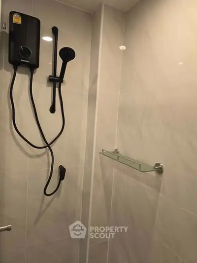 Modern bathroom shower area with sleek design and wall-mounted showerhead.