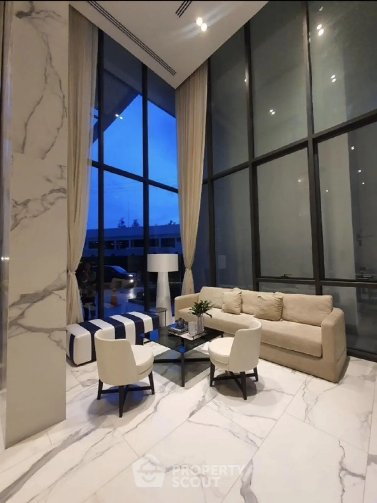 Luxurious high-ceiling living room with marble floors and elegant furniture