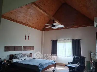 Spacious bedroom with high wooden ceiling and cozy furnishings