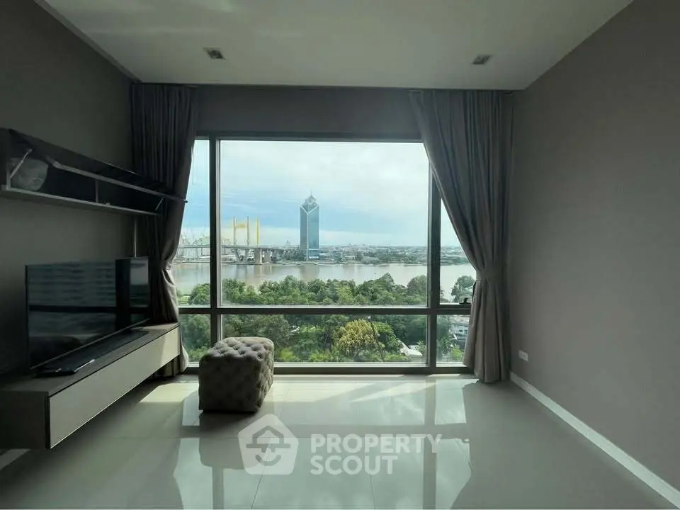 Stunning living room with floor-to-ceiling windows offering breathtaking river and city views.