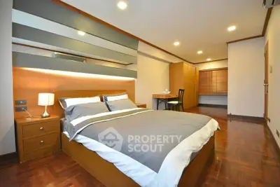 Spacious modern bedroom with wooden flooring and stylish decor