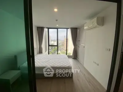 Modern bedroom with large windows and city view, featuring air conditioning and minimalist design.