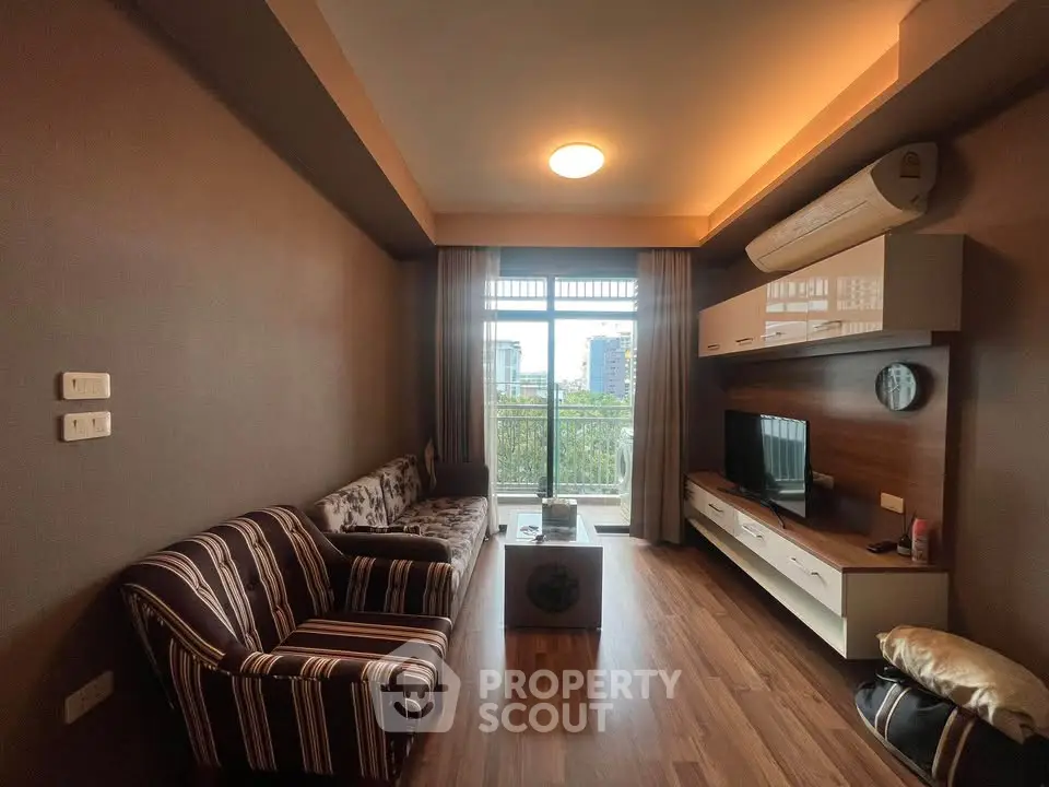 Stylish living room with modern decor and city view balcony, perfect for urban living.