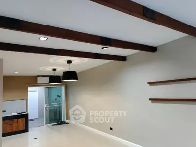Modern living room with exposed beams and stylish lighting