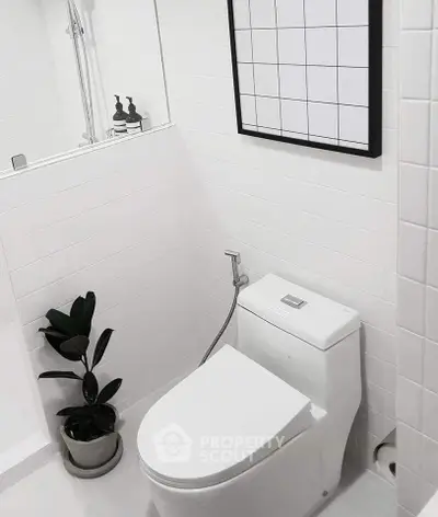 Modern minimalist bathroom with sleek white tiles and contemporary fixtures.