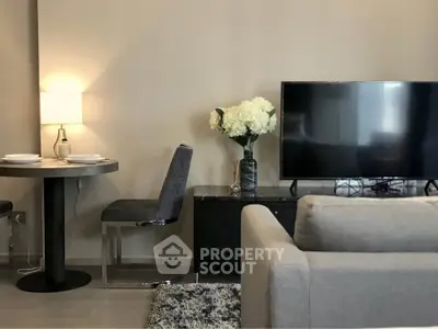 Modern living room with cozy seating, flat-screen TV, and elegant dining area.