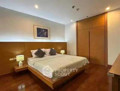 Modern bedroom with wooden accents and ambient lighting, featuring a cozy bed and stylish decor.