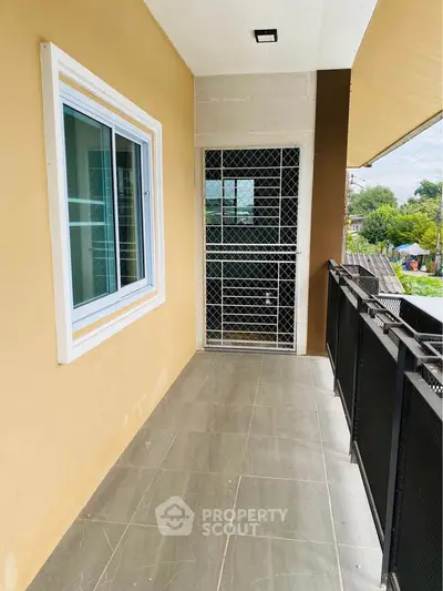 Spacious balcony with tiled flooring and modern railing, perfect for outdoor relaxation.