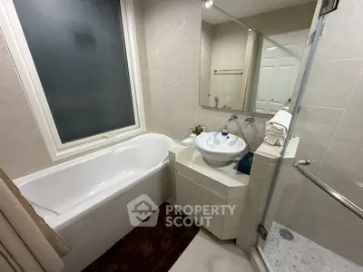 Modern bathroom with bathtub and glass shower enclosure