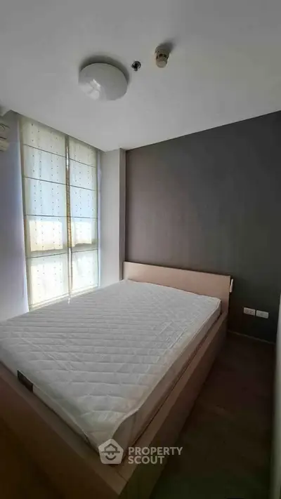 Modern bedroom with large window and minimalist design in a stylish apartment.