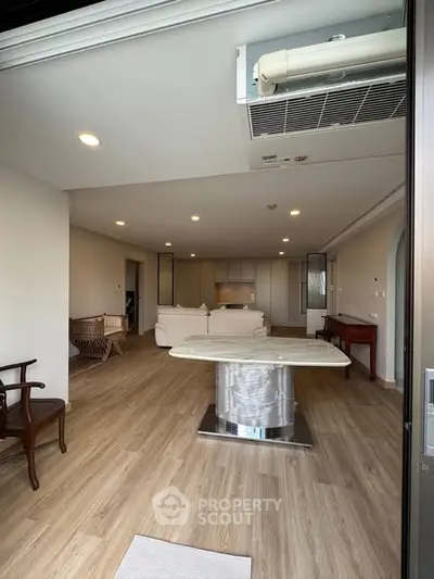 Spacious open-plan living room with modern decor and wooden flooring
