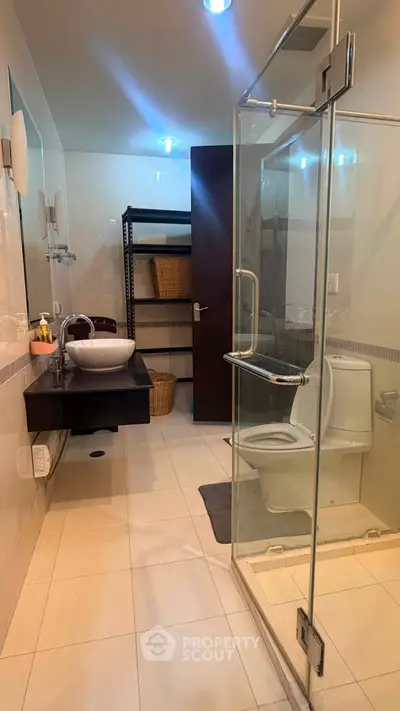 Modern bathroom with glass shower and sleek vanity in contemporary home.