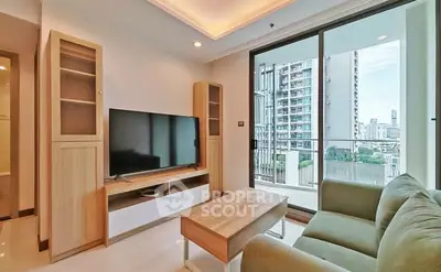 Modern living room with large TV and balcony view in urban apartment