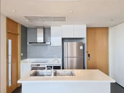 Modern kitchen with sleek appliances and island in contemporary apartment