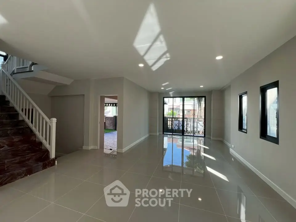 Spacious modern living room with glossy tile flooring and large windows for natural light.