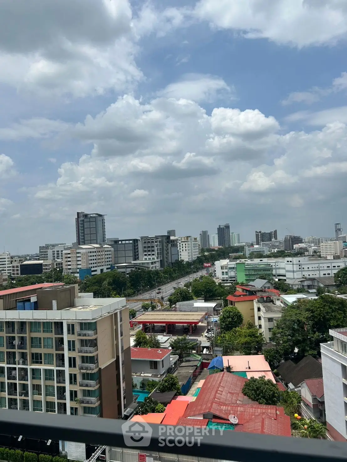 Stunning cityscape view from a high-rise balcony showcasing urban skyline and lush greenery.