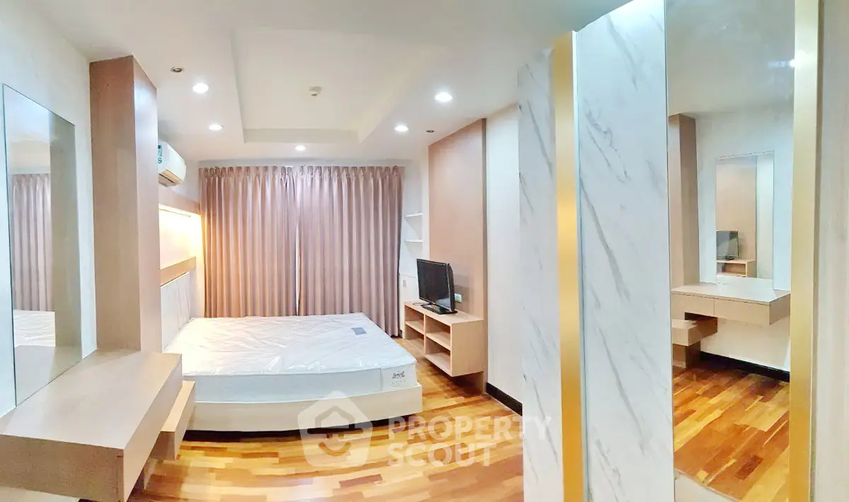 Spacious modern bedroom with wooden flooring and stylish decor