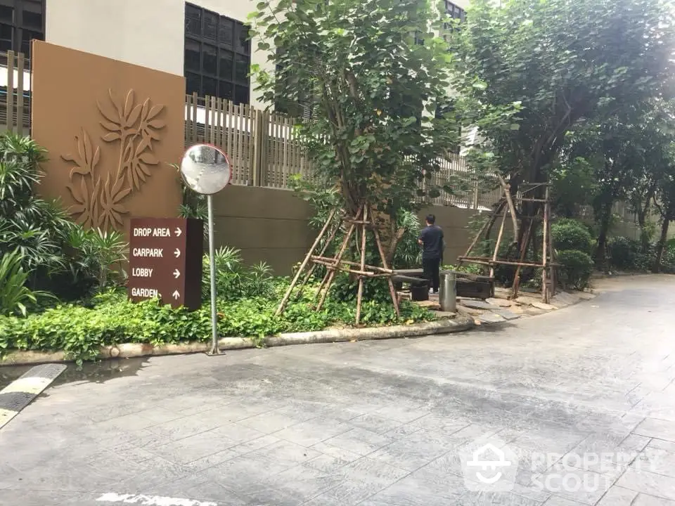 Elegant garden entrance with lush greenery and directional signage