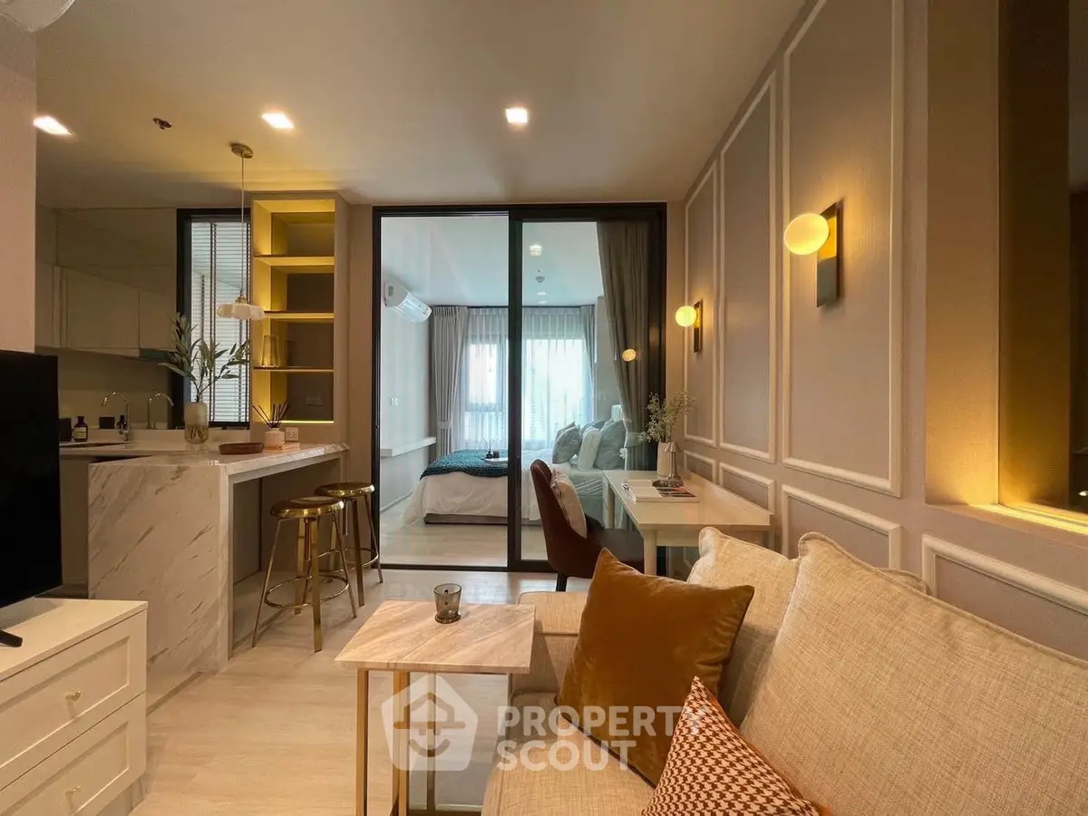 Luxurious open-plan living room with modern kitchen and cozy bedroom view.