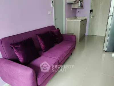 Modern apartment with purple sofa and compact kitchen area