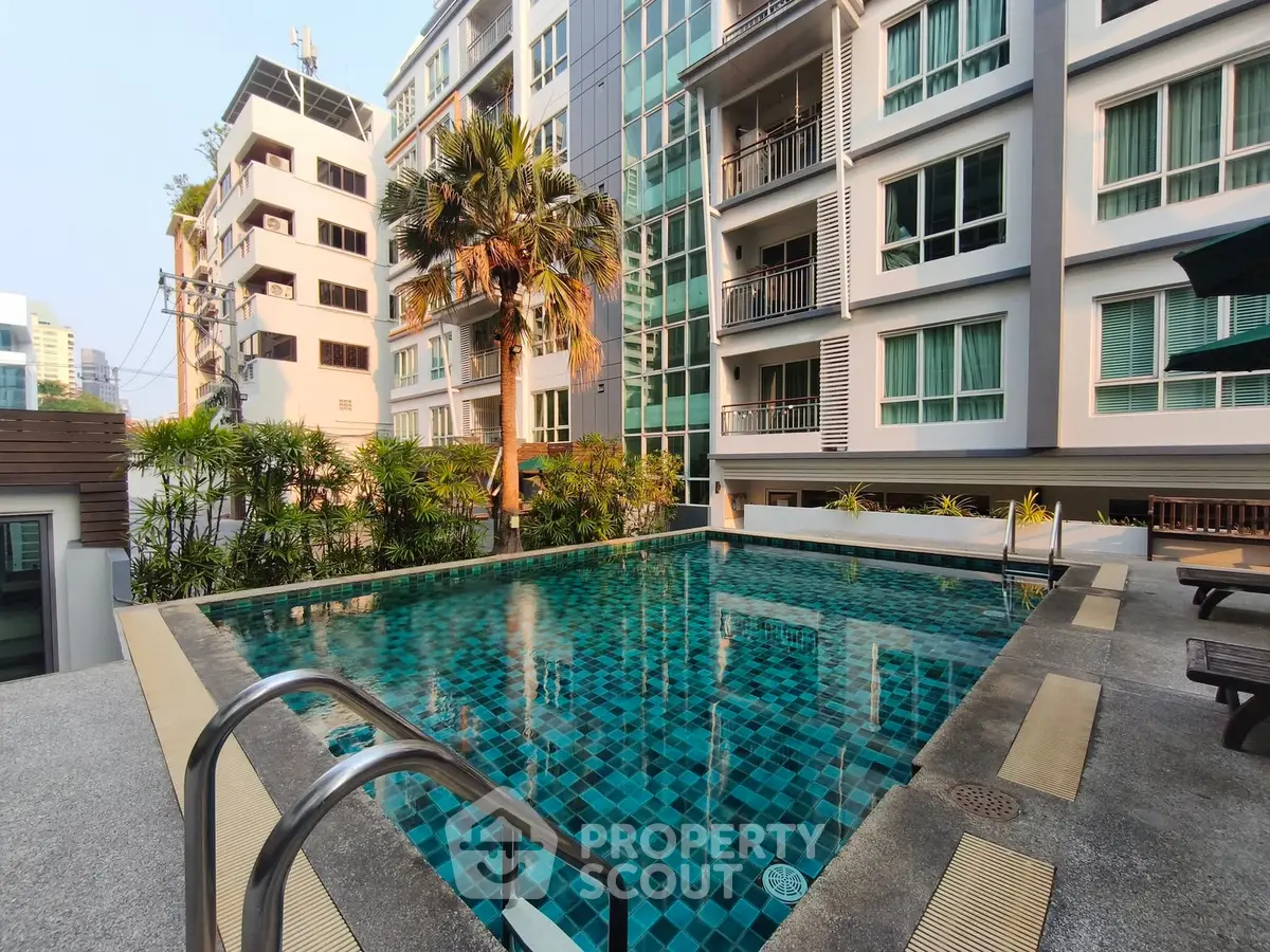 Luxurious residential building with a stunning outdoor pool and lush greenery, perfect for relaxation and leisure.