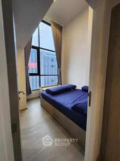 Modern bedroom with large window and city view, featuring sleek design and cozy atmosphere.