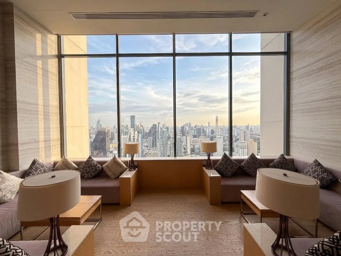 Luxurious living room with panoramic city view, featuring elegant seating and floor-to-ceiling windows.