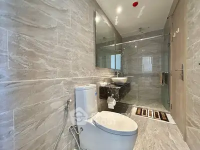 Modern bathroom with sleek design, featuring a glass shower and elegant fixtures.