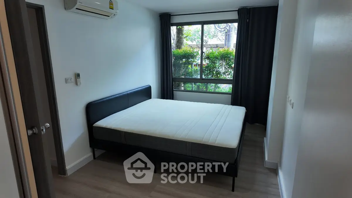 Modern bedroom with large window and minimalist design in a real estate property.